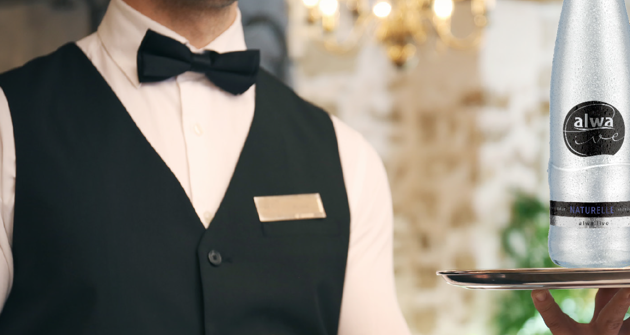 Kellner mit alwa live, das stille Mineralwasser für die Gastronomie, auf Tablett