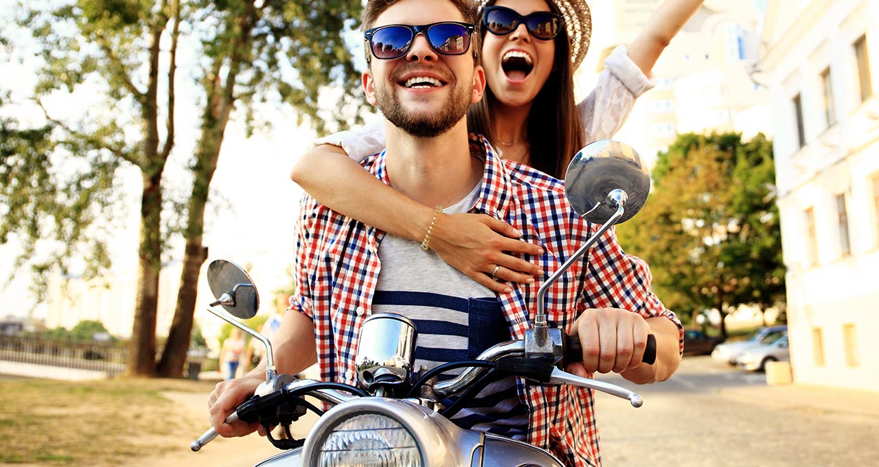 Junge Mann und Frau auf Roller