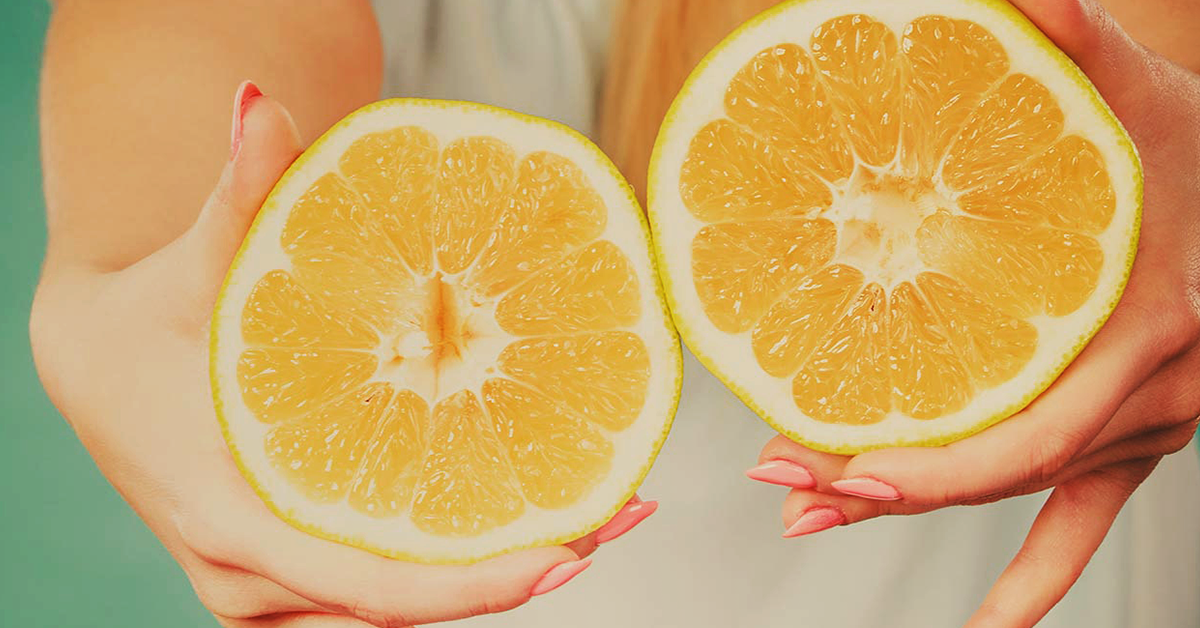 Frauenhände mit halbierten Grapefruits