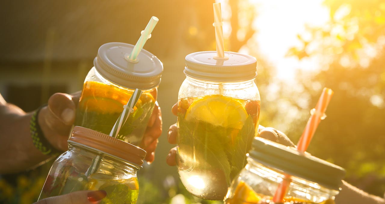 Zitronenlimonade ohne Zucker im Glas mit Deckel und Strohhalm