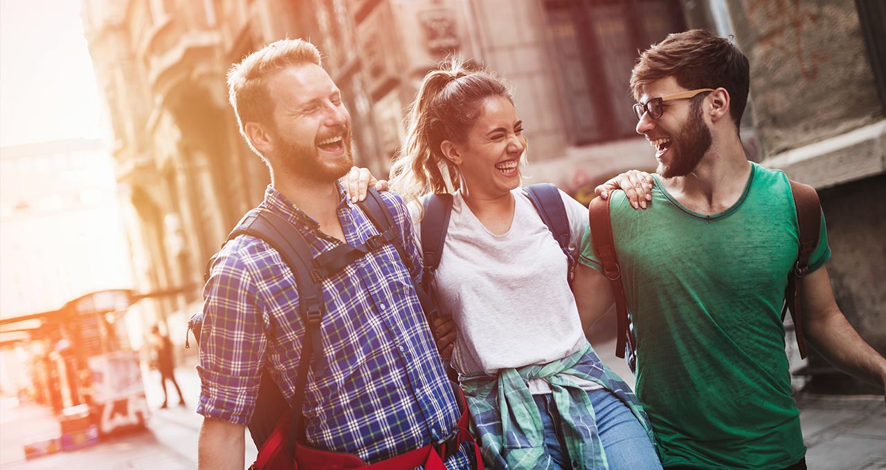 Drei junge Erwachsene lachend in der Stadt