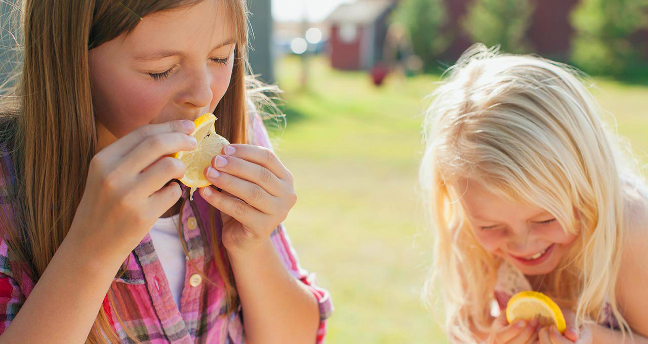 Mädchen beißen in Zitronenscheiben