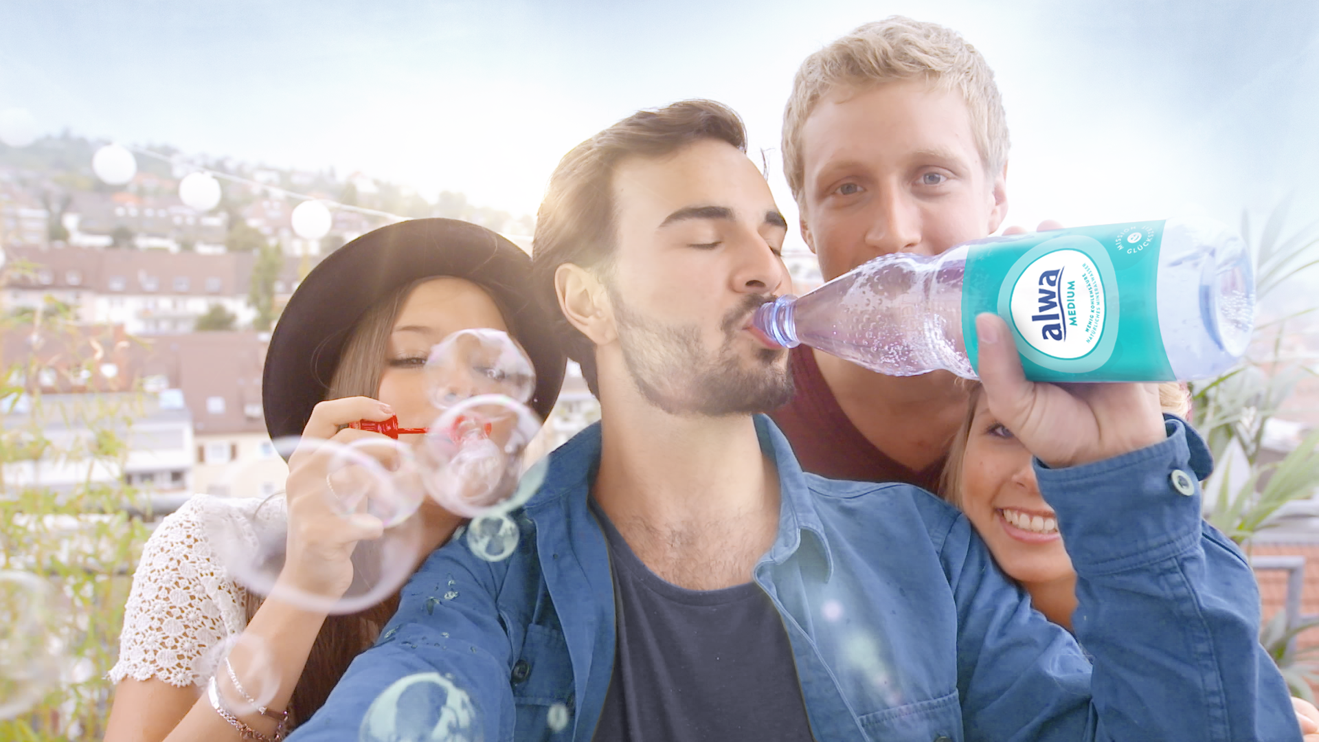 Junge Menschen mit Seifenblasen und Mineralwasser medium