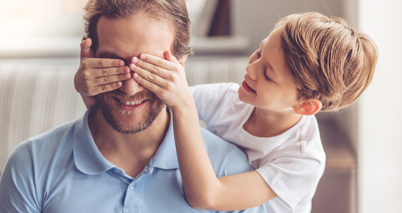 Junge hält Mann die Augen zu