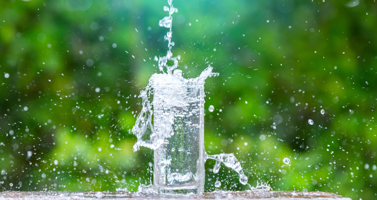 Mineralwasser medium spritzt aus Glas