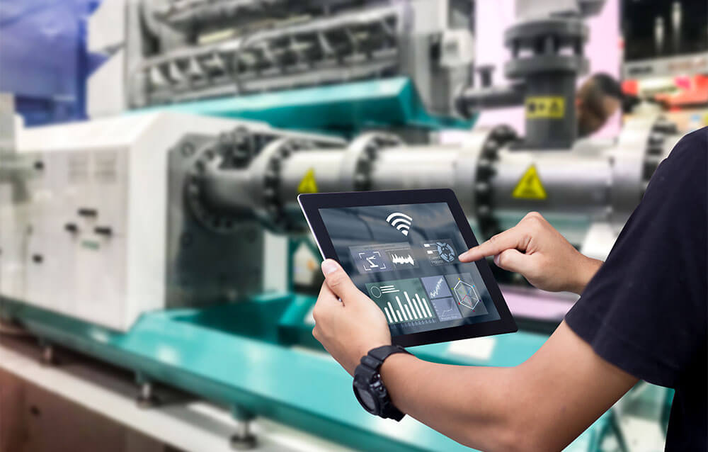 Person tippt auf iPad in Produktionshalle