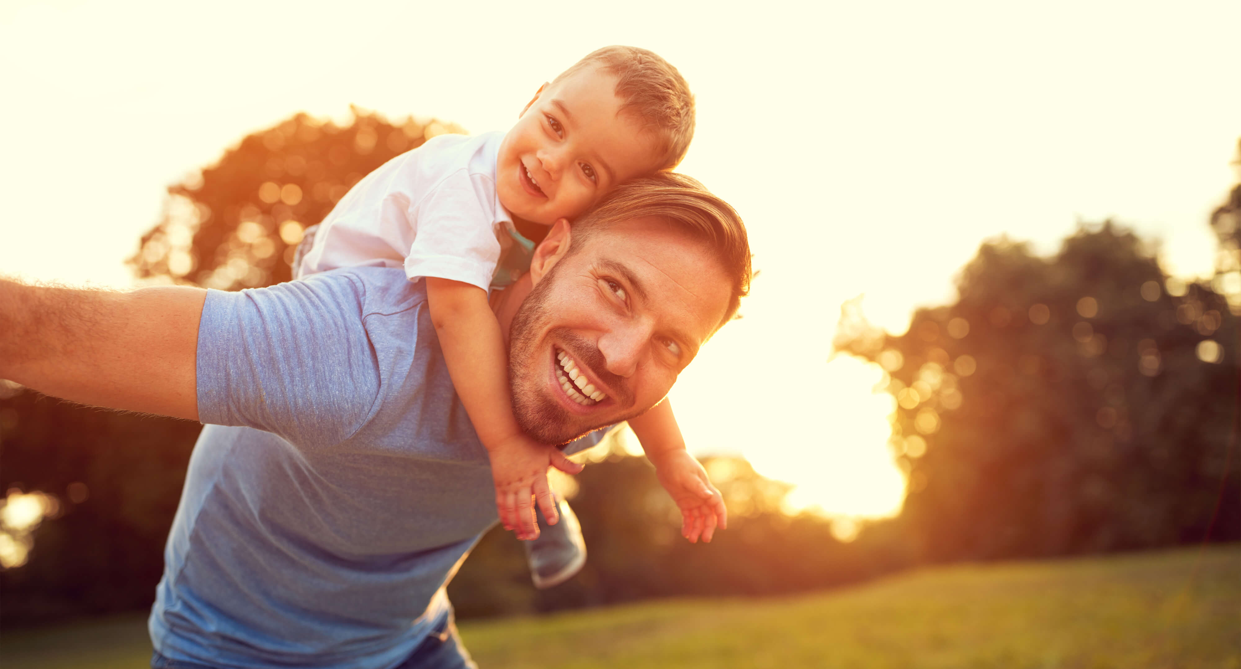 Vater nimmt Sohn Huckepack