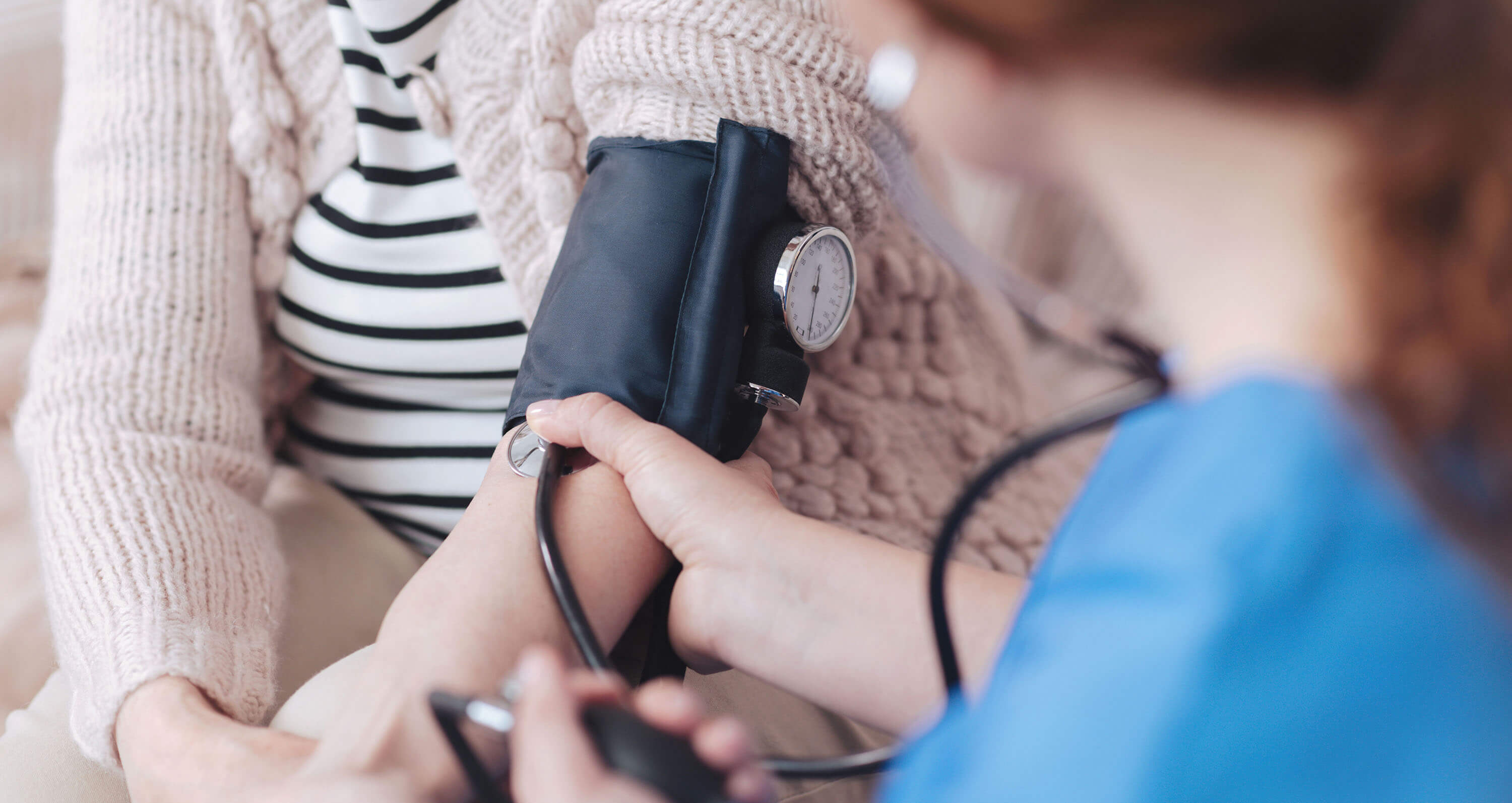 Frau misst bei einer anderen Frau den Blutdruck