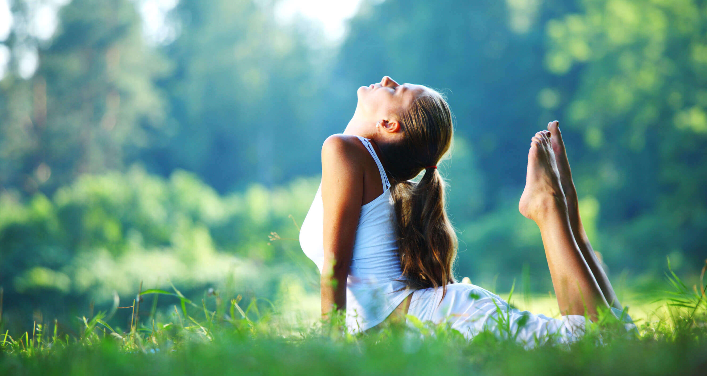 Frau macht Yoga im Grünen