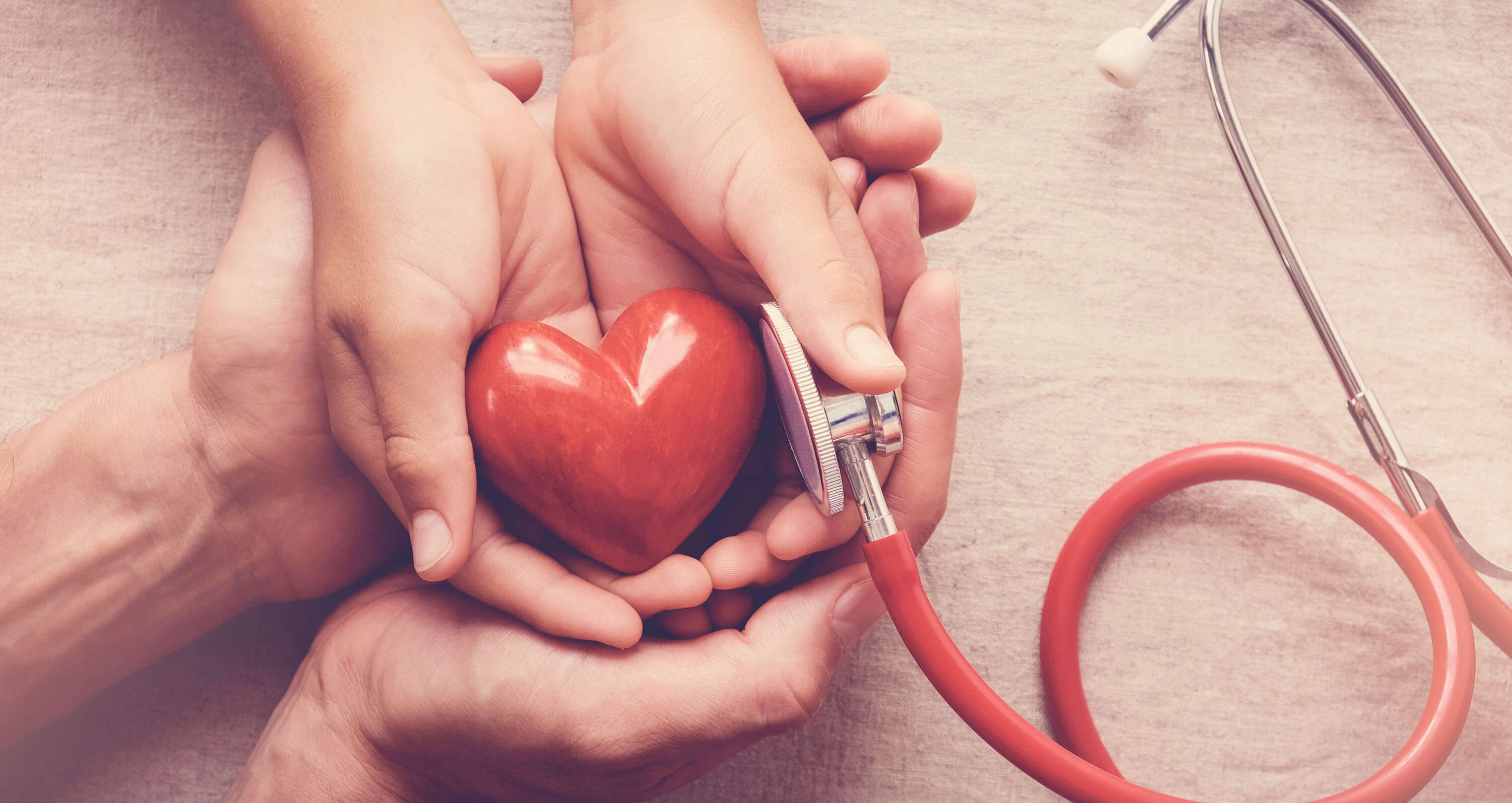 Hände mit Herz und Stethoskop