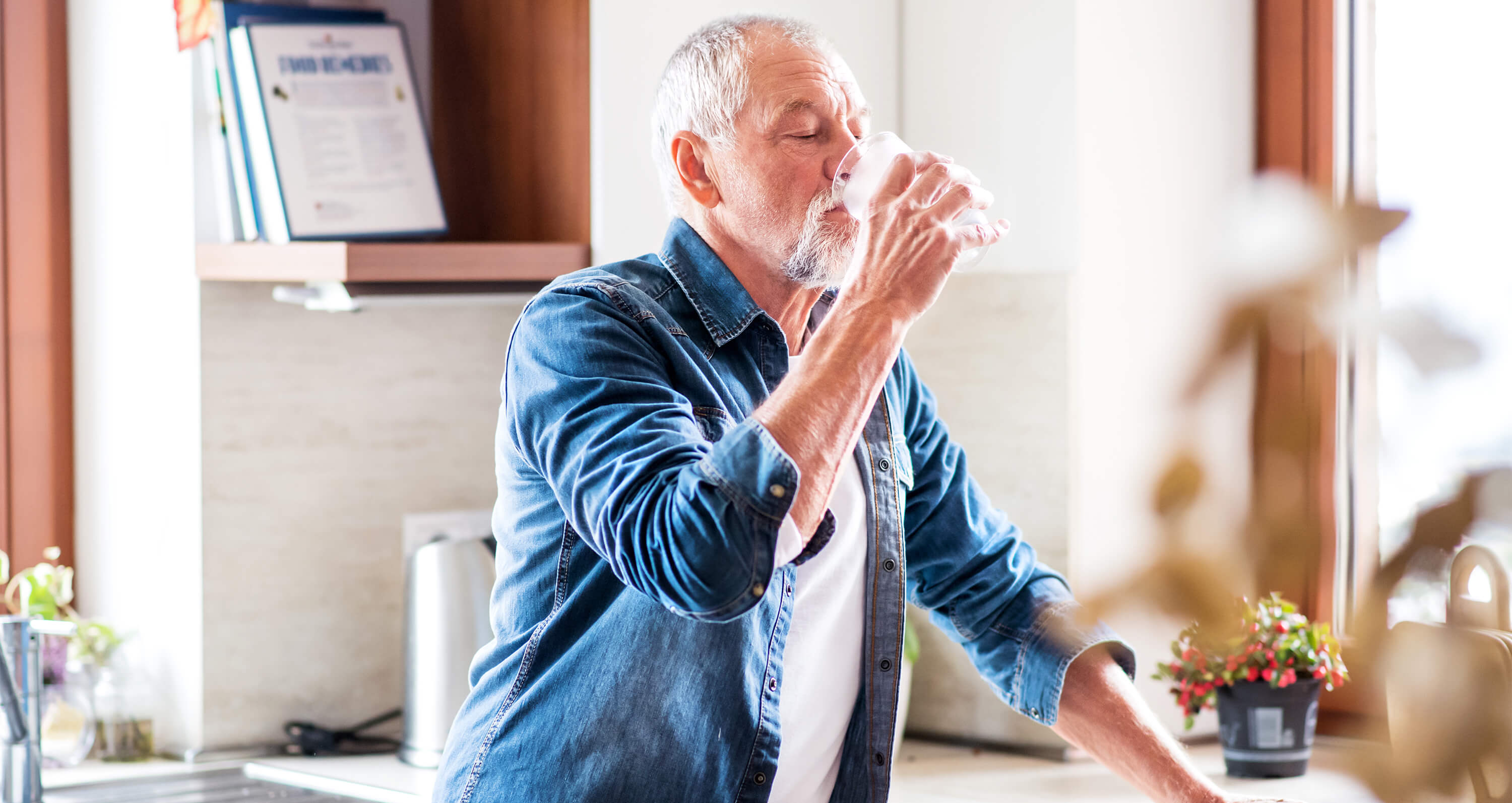 Senior trinkt Mineralwasser aus einem Glas