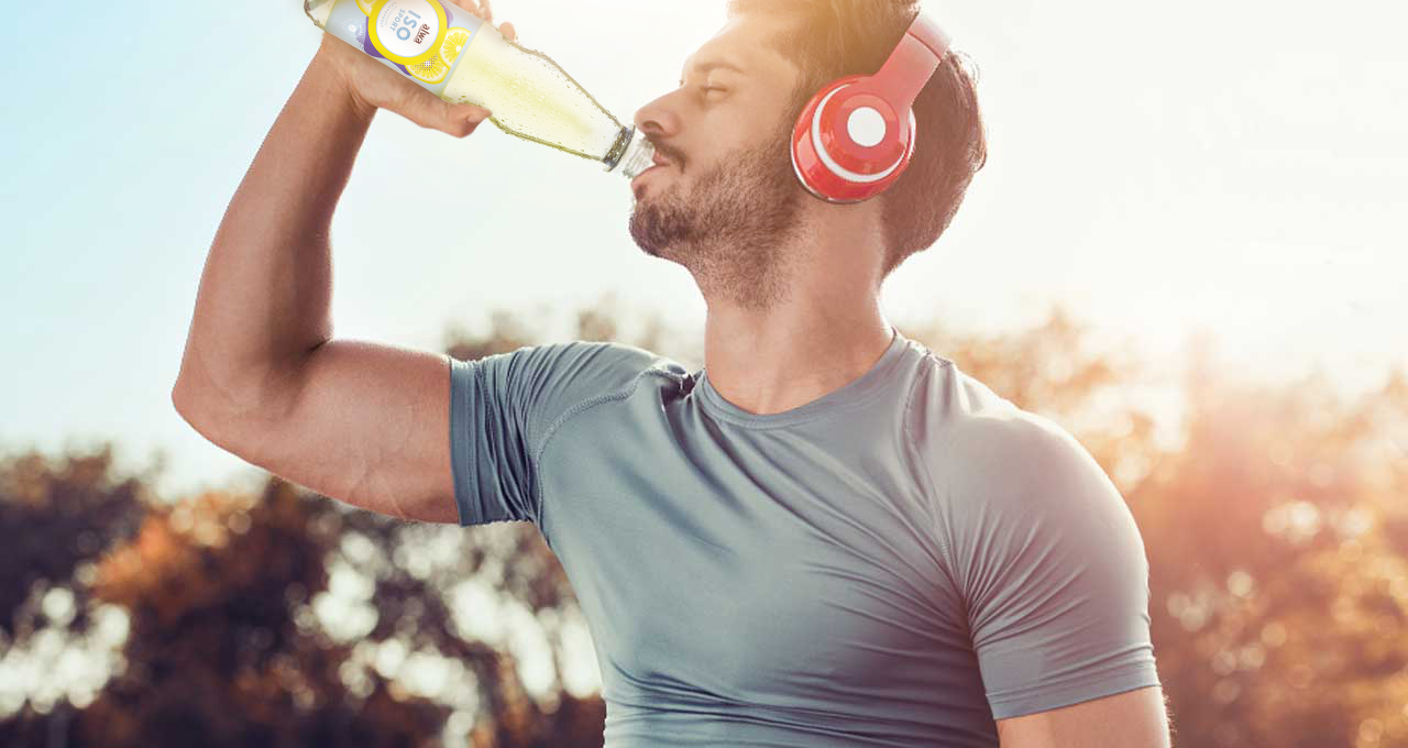 Mann mit roten Kopfhörern trinkt beim Sport