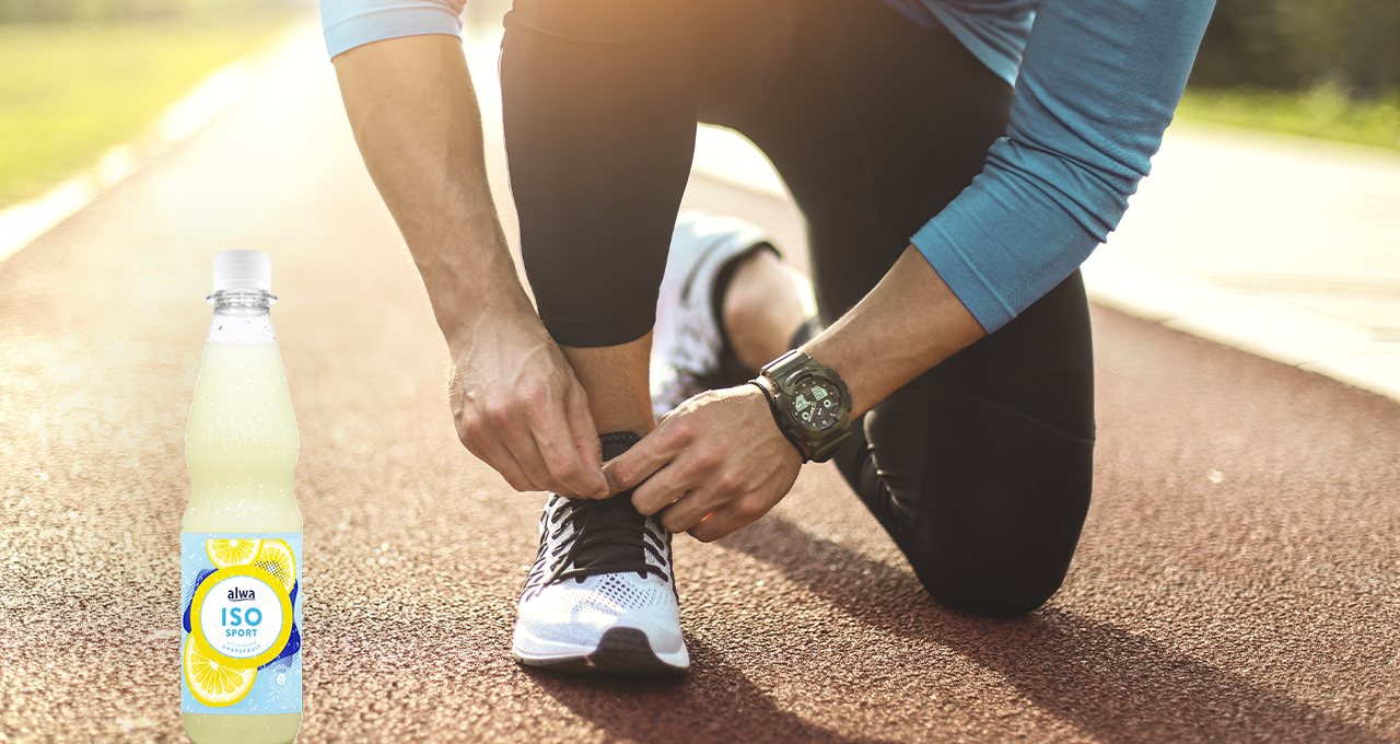 Mann schnürt Sportschuhe auf Tartanbahn