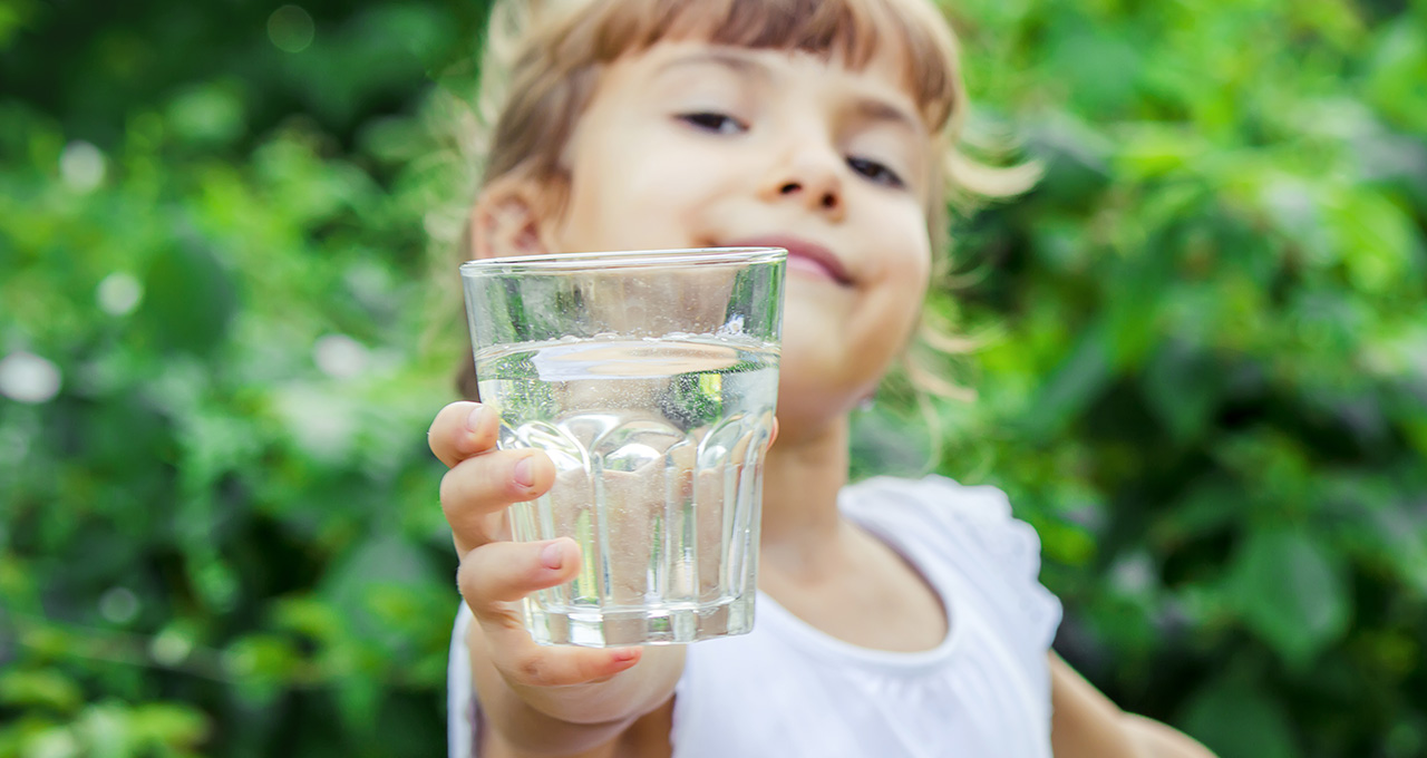 Kind mit Wasserglas in der Hand