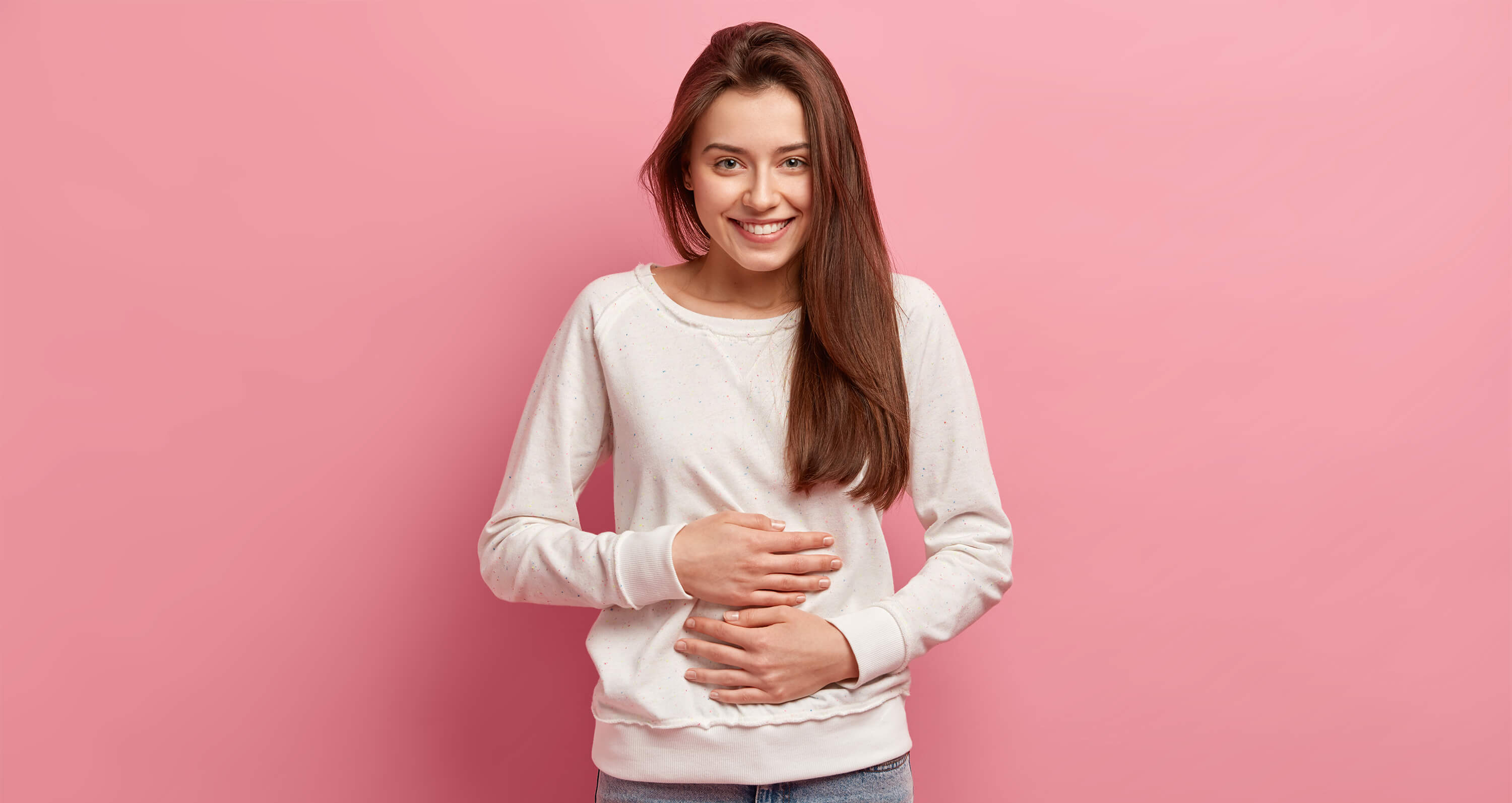 Junge Frau mit auf dem Bauch liegenden Händen