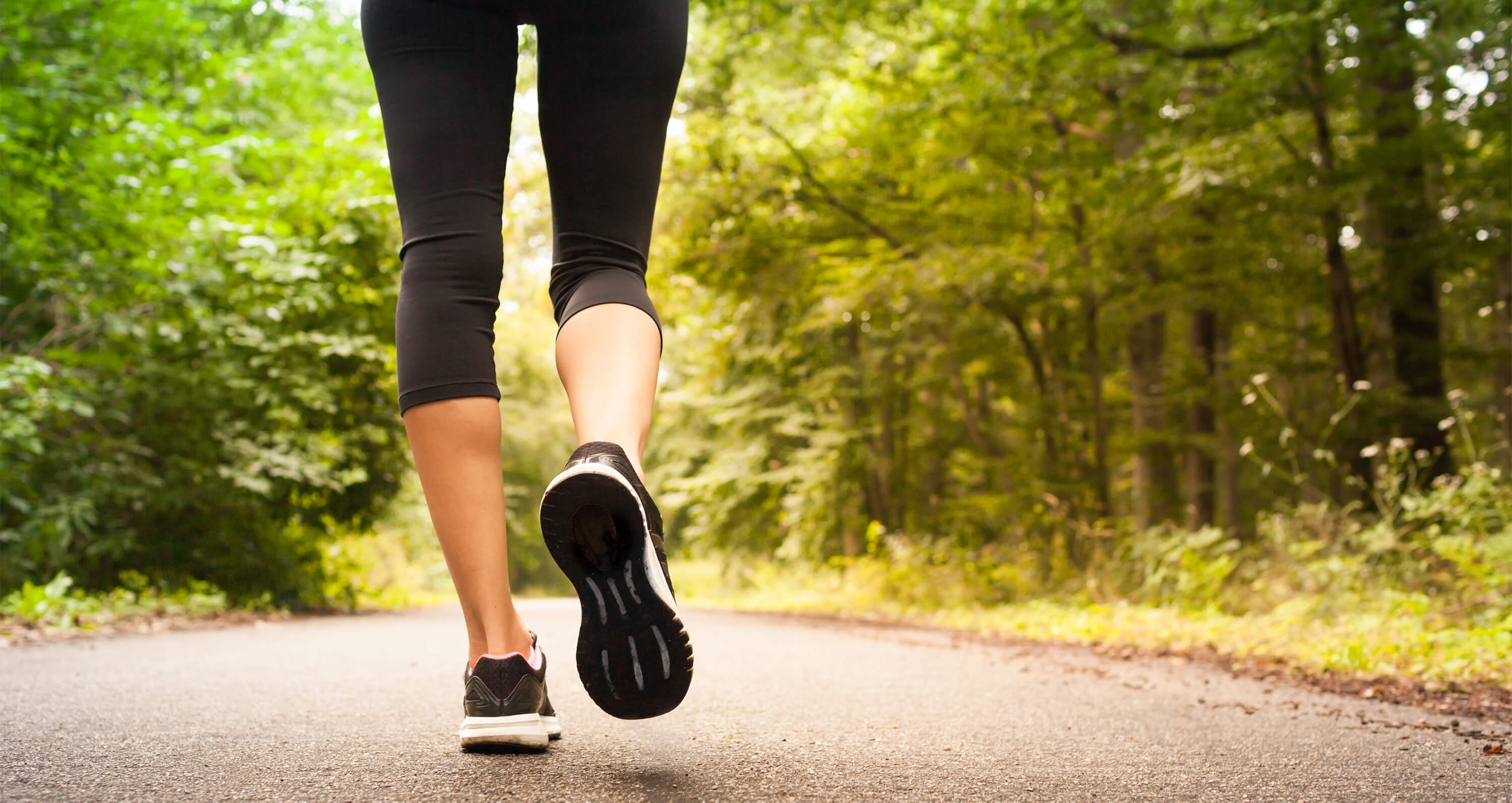 Beine, die durch einen Wald joggen