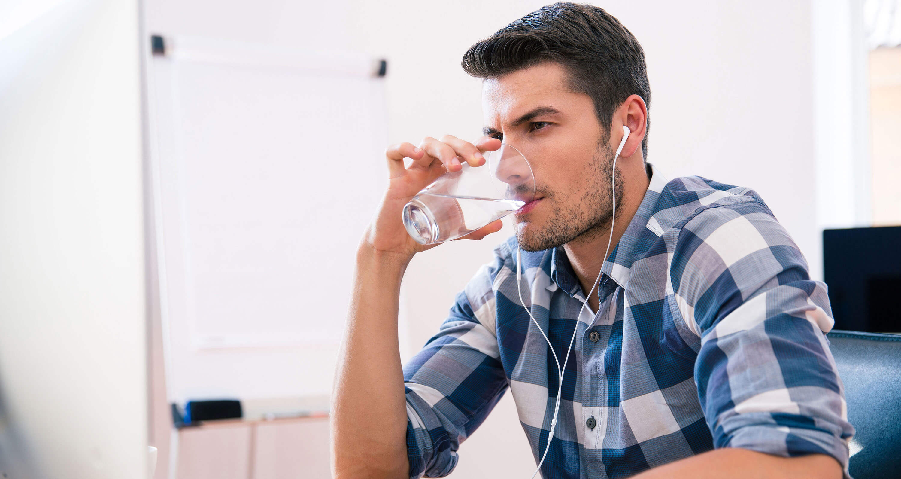 Mann trinkt aus Wasserglas