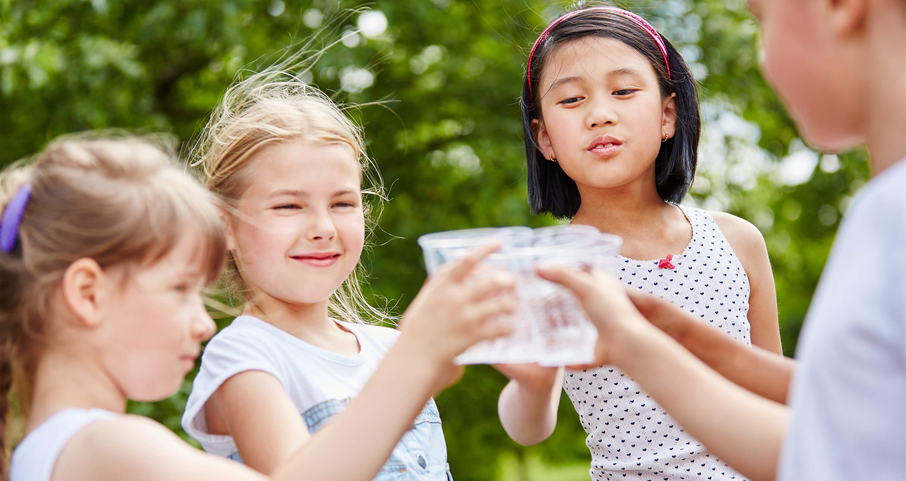 Kinder stoßen mit Gläsern an